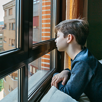 Junge guckt aus dem Fenster