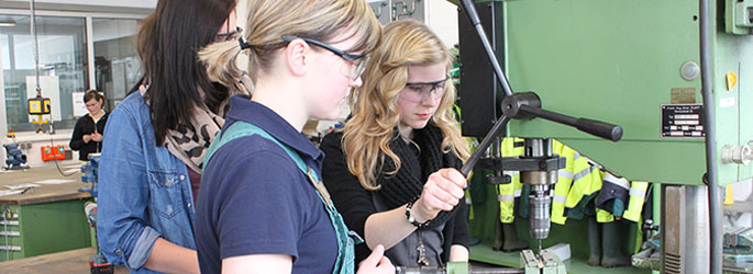 SchülerInnen an einer Standbohrmaschine