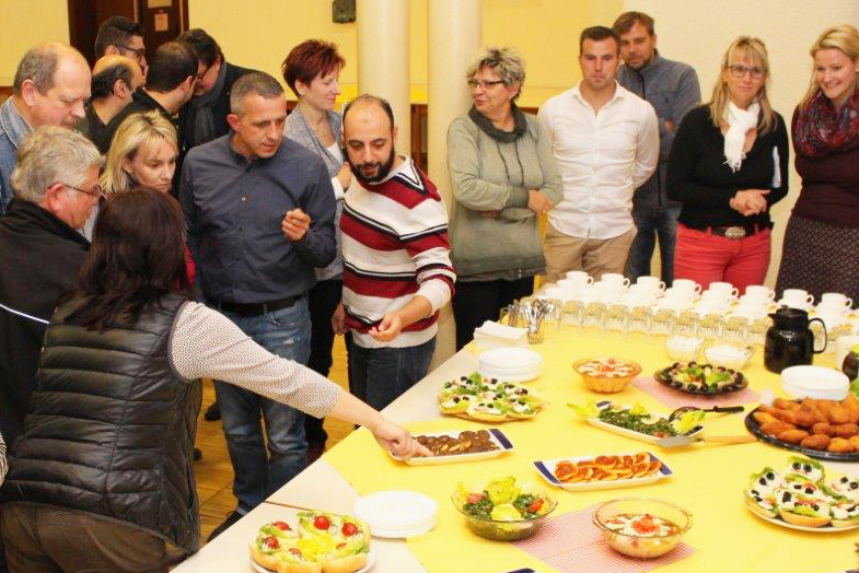 Teilnehmer erklären die Herkunft diverser Speisen des Buffets