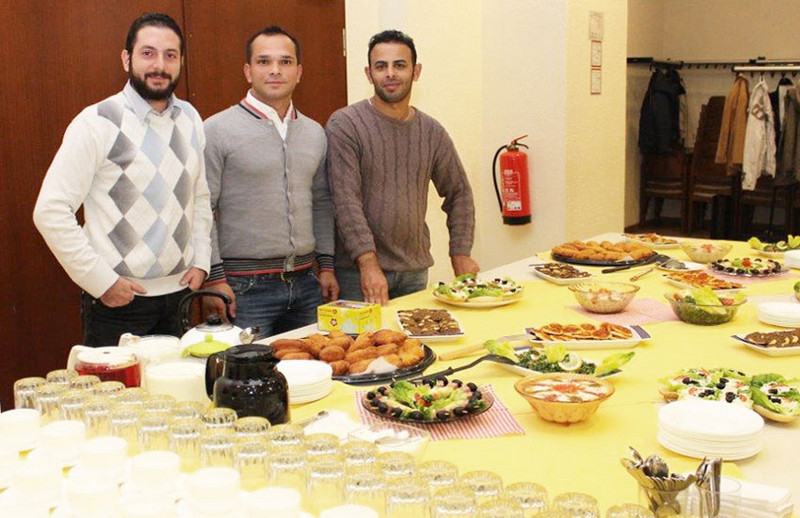 Teilnehmer anderer Kulturen vor einem Buffet