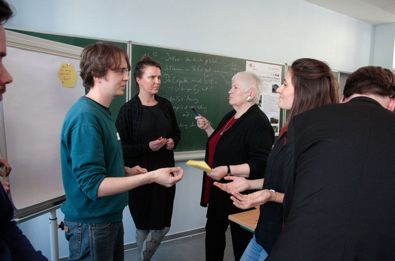 Gruppe bespricht sich vor einem Whiteboard